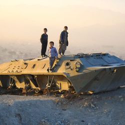 Kinder spielen auf einem Panzer auf dem Bibi Maru Hill in Afghanistan.