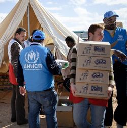 Geflüchtete aus Libyen an der ägyptisch-libyschen Grenze werden vom UNHCR mit Lebensmitteln versorgt.