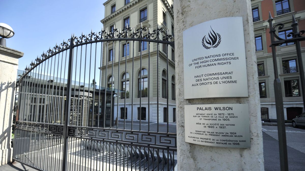 Neben dem Eingangstors befinden sich zwei Plaketten mit der Aufschrift: United Nations Office of the High Commissioner for Human Rights. Palais Wilson. Im Hintergrund ist der Palast.