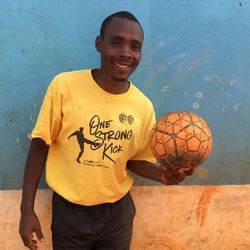 Anaclet Nkunzimana, 36, arbeitete im Mtendeli Camp in Tansania als Fußballtrainer für Kinder und Jugendliche Ein Mann hält lächelnd einen Fußball in der Hand