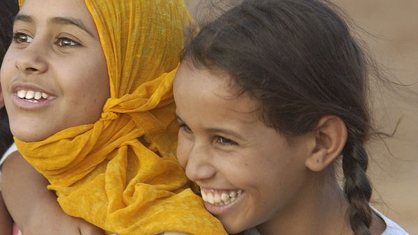 Zwei junge Mädchen in Nahaufnahme lächeln und lachen in die Kamera